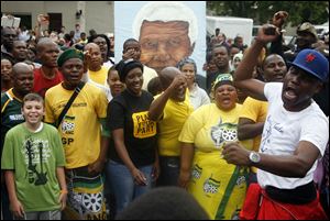 A group of mourners sing and dance outside the Johannesburg home of former president Nelson Mandela. Mandela passed away Thursday night after a long illness. He was 95. 