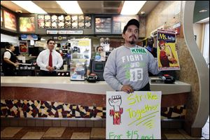 Protester Juan Navarro demonstrates in front of the counter at a McDonald's restaurant Thursday Los Angeles. Demonstrations were planned nation-wide as a part of push by labor unions, worker advocacy groups and Democrats to raise the federal minimum wage of $7.25 to $15. 