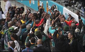 People dance as they arrive for the memorial service for former South African president Nelson Mandela at the FNB Stadium in Soweto, near Johannesburg, South Africa.