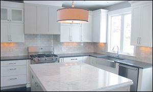 Carrara marble tops the large kitchen island and contrasts with the steel gray countertop.