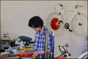 Mechanical and software engineer Julian Fong works on the Copenhagen Wheel, the red disk that is a human/electric hybrid bicycle engine. The wheel was developed at Superpedestrian Inc. in Cambridge, Mass.