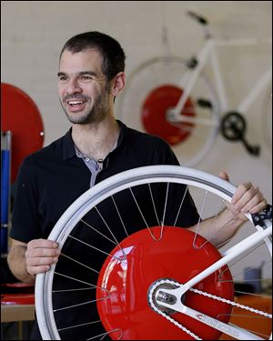 Assaf Biderman, co-inventor of the Copenhagen Wheel, shows off his human/electric hybrid engine built into a bicycle's back wheel. The device packs sufficient power to propel a rider up to 37 mph.