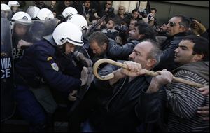 Farmers clash with riot police outside Greece's parliament in Athens on today.