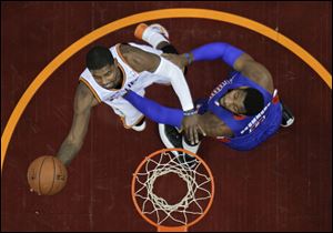 Cleveland Cavaliers' Kyrie Irving, left, shoots against Detroit Pistons' Andre Drummond during the first quarter.