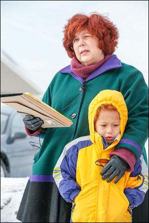 Karen Shanahan  has an arm around grandson Eoghan Shanahan, 5, as she speaks during a news conference at Heatherdowns Boulevard and Key Street on Thursday.