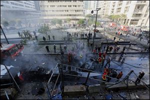 Lebanese firefighters extinguish burned vehicles at the scene of an explosion in Beirut, Lebanon, today.