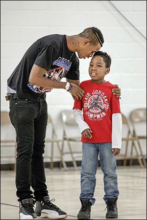 Jared Frazier and his son Jeremiah confer before the father-son game.