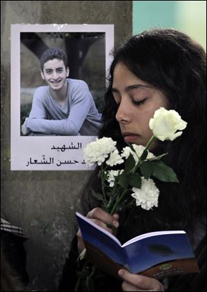 A Lebanese student of the private Hariri High School reads verses from Islam's Quran for 16-year-old Mohammed Shaar.