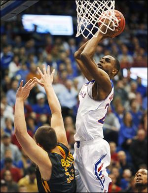 Kansas guard Andrew Wiggins, right, shoots over Toledo center Nathan Boothe, left, during the first half.