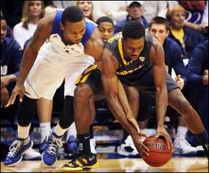 Kansas guard Wayne Selden, left, and Toledo guard Justin Drummond, right, battle for the ball during the first half in Lawrence, Kan..