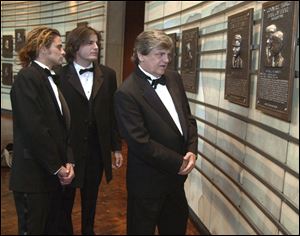 In this Oct. 4, 2001 file photo, Phil Everly, right, of the musical duo The Everly Brothers, looks at his plaque in the Country Music Hall of Fame along with his sons, Chris, left, and Jason, in Nashville, Tenn.