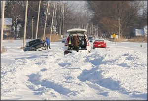 Stuck vehicles on Suder Avenue near Lotus Drive in Erie, Mich., were among many throughout the region after a few days of snow and cold. By Saturday, however, when the high temperature is predicted to be 40 degrees, with rain likely, flooding might be a problem in the area.