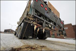 In a demonstration, a Pennsylvania Department of Transportation anti-icing truck sprays a de-icing cocktail of brine and beet juice on the driveway of PennDot's Butler, Pa., maintenance facility, Monday.