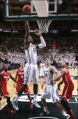 Branden Dawson lays the ball up as Ohio State's Shanon Scott (3), Aaron Craft (4), and LaQuinton Ross, right, and Michigan State's Gavin Schilling (34) watch.