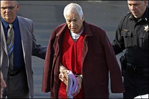 Former Penn State University assistant football coach Jerry Sandusky, center, leaves the Centre County Courthouse after attending a post-sentence motion hearing in Bellefonte, Pa. in January, 2013.