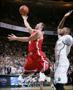 Ohio State's Aaron Craft, left, puts up a layup against Michigan State's Adreian Payne during the first half . Craft was instrumental in getting the Buckeyes to overtime, but his effort wasn’t enough.