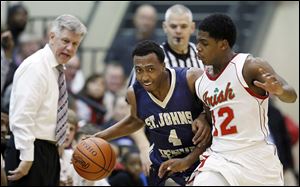 Anthony Glover, Jr., of St. John’s, left, drives against  Central Catholic’s Jermiah Braswell during their game on Friday night.