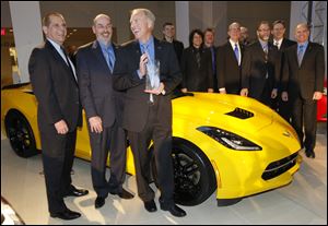 Corvette chief engineer Tadge Juechter, third from left, jokes as he poses with his team after accepting the award for North American Car of the Year at the North American International Auto Show in Detroit, today.