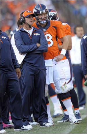 Denver Broncos quarterback Peyton Manning and offensive coordinator Adam Gase look at the scoreboard during a recent game.