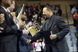 Ray Wood, right, president of the Toledo branch of the NAACP, right, shakes hands with Unity Award winner Sam Robinson.