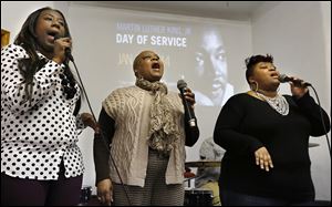 Natasha Campbell, Beatrice Taylor, and Irene Campbell, from left, sing during a Martin Luther King, Jr., Day event at Salem Baptist Church on Vance Street in Toledo.  The service was followed by a meal at the MLK Kitchen for the Poor next door.