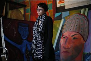 Local artist and resident Chloey Wilburn stands in stands next to her painting, left, in a friend's studio at the Collingwood Arts Center Wednesday. The 28 residents of the Collingwood Arts Center have to move in 30 days because of 