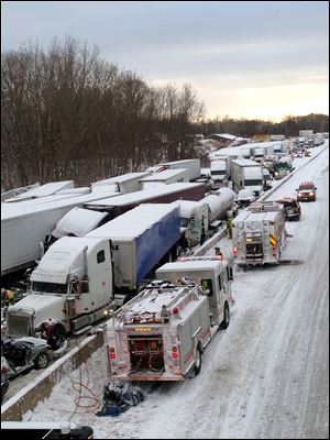 Emergency crews work at the scene of a massive pileup involving about 15 semitrailers and about 15 passenger vehicles and pickup trucks along Interstate 94 Thursday near Michigan City, Ind. 