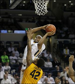 Toledo’s J.D. Weatherspoon shoots while being defended by Kent State’s Darren Goodson. The Rockets improved to 7-0 in games decided by four points or less.