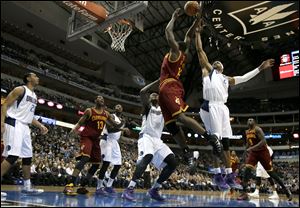 Cleveland Cavaliers forward Anthony Bennett (15) has the ball slapped away on a dunk attempt by Dallas Mavericks' Vince Carter (25) as Devin Harris (20), Tristan Thompson (13), Jae Crowder, center rear, Samuel Dalembert (1) of Haiti and Luol Deng (9) of Sudan watch.