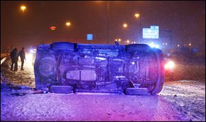 Police respond to an overturned car on I-75 South near the Miami St. onramp in Toledo.