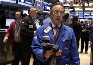 Trader Steven Kaplan, center, works on the floor of the New York Stock Exchange. Stocks are mixed on Wall Street after suffering big losses the day before.