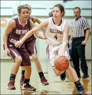 Rossford's Julie Hotz drives past Genoa's Ciara Albright. Hotz led the Bulldogs with 15 points. Albright led all scorers with 26 points, surpassing 1,000 for her career.