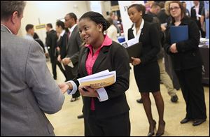 Finance major Ezinwa Omodom, center, discusses internships with a representative of  3M Frontline during a job fair at the University of Toledo’s College of Business and Innovation. A U.S. report Friday  showed the sizable employment gap between those with college degrees and those without a high school diploma. 