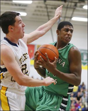 Ottawa Hills’ Ellis Cummings grabs one of his seven rebounds on Friday night. Toledo Christian’s Nathan Walton is at left.