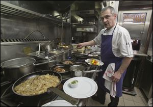 Chef Thierry Laurent prepares the plates in the kitchen of the Bistro Paul Bert in the trendy 11th arrondissement  of Paris.  Laurent,  chef at Paul Bert for 14 years, is proud to cook each dish in the purest French tradition.