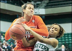 Erica Donovan is fouled by Eastern Michigan's Cha Sweeney during the second half. Sweeney, a Rogers grad, scored 10 points.