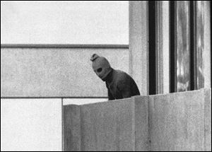 Amasked terrorist stands on the balcony of the building where the Arab group Black September was holding members of the Israeli Olympic team hostage during the 1972 Summer Olympics in Munich, Germany. 