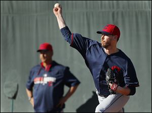 Cleveland Indians pitcher John Axford throws as manager Terry Francona looks on during spring training in Goodyear, Ariz. Axford is expected to replace Chris Perez as the Tribe’s closer.