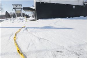 Police security tape remains outside of Club Status on Airport Highway. Police are investigating the apparent shooting death of Lamar Booker at the club on Sunday.