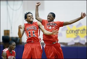 Rogers' Branden Austin (11) celebrates scoring the game-winning-three-point-basket against Scott with team mate Daeshawn Jackson (24) during the City League boys basketball playoff semifinals.