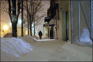 People linger outside St. Paul’s Community Center as they seek warmth during a snowstorm.