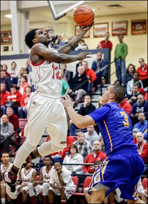 Central Catholic Jermiah Braswell (12) goes to the basket against Findlay's Chase Miller (3).