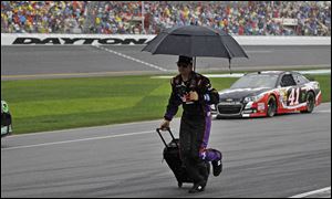 A crew member runs down pit road during a rain delay in the Daytona 500 on Sunday at Daytona International Speedway in Daytona Beach, Fla.