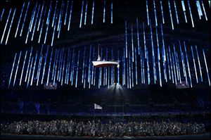 A boat is suspended in the air as performers participate in the closing ceremony of the 2014 Winter Olympics.