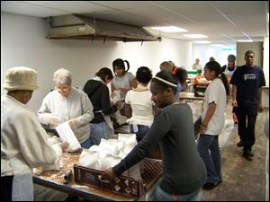 Volunteers prepare paczki to be sold at the annual sale for ONE Village Council. 