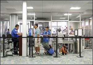 Passengers go through security at Toledo Express Airport. Need to add a line from the story to make second line, Passenger traffic in Toledo grew from 159,295 travelers in 2013 from 143,514 in 2012.