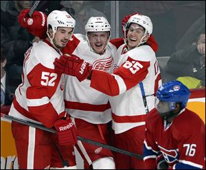 Detroit Red Wings center Gustav Nyquist (14) celebrates his winning goal with defensemen Jonathan Ericsson (52) and Danny DeKeyser (65).