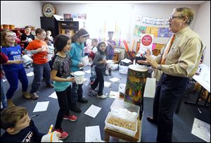 Ethnomusicologist Craig Woodson leads third graders in a music jam during a visit to Dorr Elementary last week. One instrument the students made was a combination drum, flute, horn, and shaker.