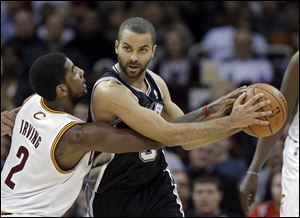 Cleveland Cavaliers' Kyrie Irving (2) tries to poke the ball away from San Antonio Spurs' Tony Parker.