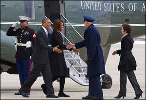 A Marine salutes as President Barack Obama and first lady Michelle Obama are greeted by 89th Airlift Wing Commander Col. David Almand and his wife Cathy Almand before boarding Air Force One for a trip to Florida.